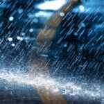 heavy rain falling on black pavement