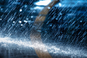 heavy rain falling on black pavement