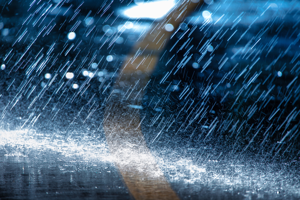 heavy rain falling on black pavement